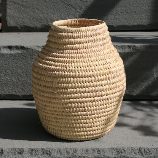 Woven beige vase on a stone surface