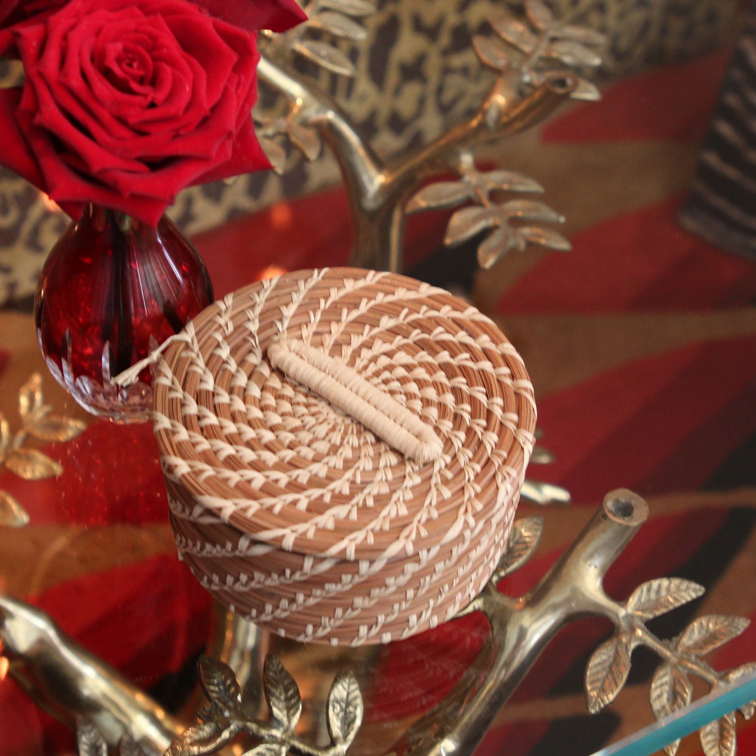 Woven basket with red roses and decorative branches in the background
